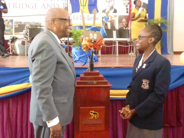 The Rt. Hon. Sir Lloyd Erskine Sandiford, former Prime Minister of Barbados and Old Scholar of the Coleridge and Parry School, and Head girl, Kiara Goodridge admiring the Commemorative Broken Trident, on its arrival to the Ashton Hall, St Peter school, yesterday.