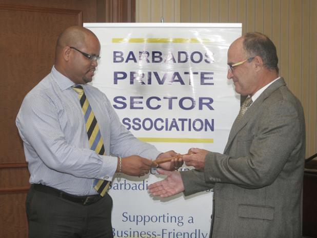 Newly installed Chairman of the Barbados Private Sector Association (BPSA), Charles Herbert (right), officially being handed control of the BPSA from former Chairman Alex McDonald during a ceremony yesterday at the Hilton Hotel. 