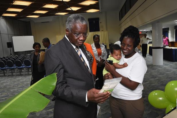 Prime Minister Freundel Stuart takes a closer look at the green banana flour being produced by Tonya Ifill of Carlesa’s Enterprises.