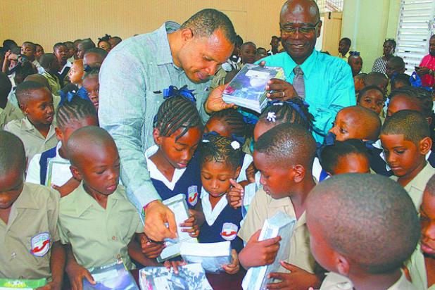 Finance Minister, Christopher Sinckler, speaking to pupils of the Eagle Hall Primary School about the exercise books he moments  earlier donated to the school, on behalf of The St. Michael North West Foundation. Also pictured is Principal of the School, Orlando Jones (right).
