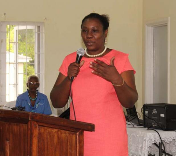 Kim Bob-Waithe of the Welfare Department goes through her presentation, as Acting Director of the National Disabilities Unit (NDU), Waple Brathwaite (seated behind her), listens on.