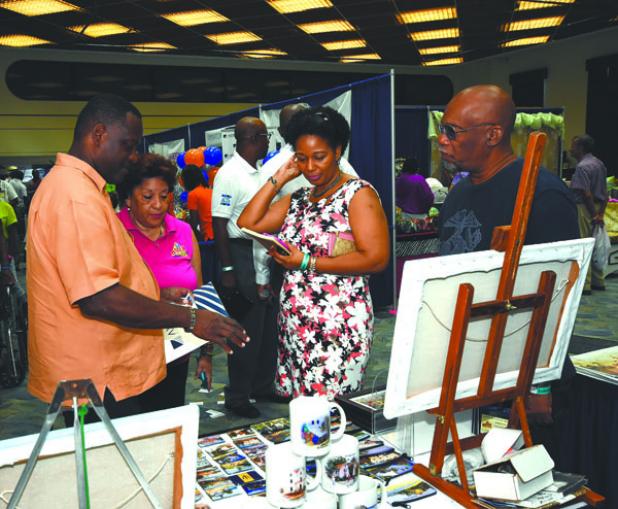 Minister of Industry, International Business, Commerce and Small Business Development, Donville Inniss (left) and Executive Director of the Barbados Manufacturers Association (BMA), Bobbi McKay (second from left) during the Minister’s tour of BMEX exhibitions yesterday at the Lloyd Erskine Sandiford Centre. (See Page 3)
