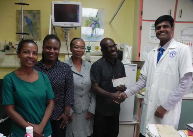 Treasurer of the A Gift For The Children charitable organisation, Tony ‘Poser’ Grazette, hands over a cheque for Bds$1 000 to Consultant in the Paediatric Intensive Care Unit (PICU), Dr. Kandamaran Krishnamurthy. Looking on is the charity’s director Andrea Marshall (second from left) as well as Senior Nursing Officer Deanis Gooding (third from left) and Registered Nurse Andrea Escamilla.