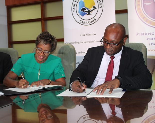 Chief Executive Officer of the FTC, Sandra Sealy (left) and Chief Executive Officer of the FSC, Kester Guy signing the MOU yesterday morning.