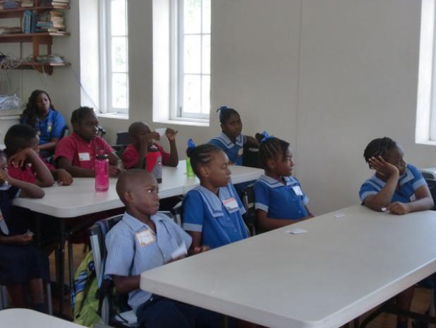 Students of St. Albans and Gordon Greenidge Primary Schools listening attentively during the opening session of the St. James Parish Independence Committee “Junior Ambassador Programme”. INSET: St. James Parish Independence Committee Project Co-ordinator, Rhonda Bryan-Hutson.