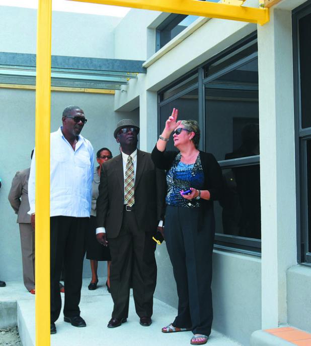 Parliamentary Secretary, Senator Harcourt Husbands, and Education Minister, Ronald Jones, listen to Chief Project Manager of the Maria Holder Trust, Jane Armstrong, as she points out some of the features of the Gall Hill nursery.