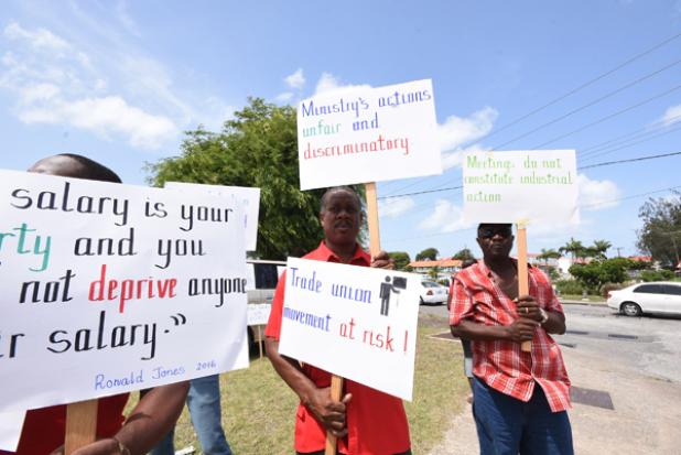 Barbados Union of Teachers (BUT) President, Pedro Shepherd (centre), and others during a peaceful protest at the playing field next to the Queen Elizabeth Hospital yesterday.