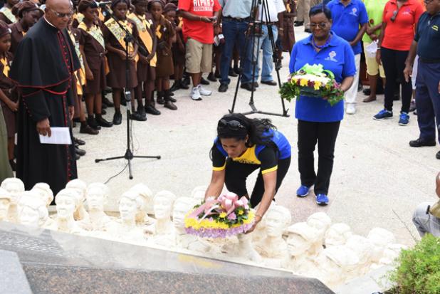 Minister of Labour, Senator Dr. Esther Byer-Suckoo lays a wreath at the statue of National Hero, the Right Excellent Sir Frank Walcott while BWU President, Linda Brooks, looks on.