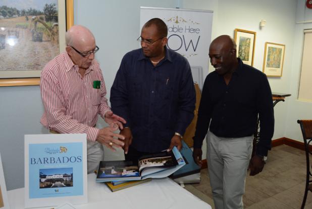 Author of the Barbados Heritage in Pictures book, Professor Emeritus Sir Henry Fraser (left), showing Minister of Tourism, Richard Sealy (centre), features of the book, as publisher Errol McCollin looks on, during Tuesday’s launch.