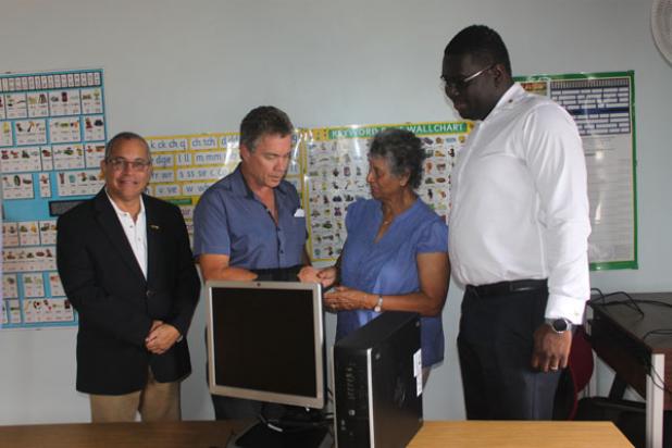 President of the Rotary Club of Barbados West, Kevin Watson, making the presentation to Director and co-founder of the Caribbean Dyslexia Centre, Yvonne Spencer. Looking on are Morton Holder, Director of the Rotary Club of Barbados West and Past President of District 7030, Milton Inniss.
