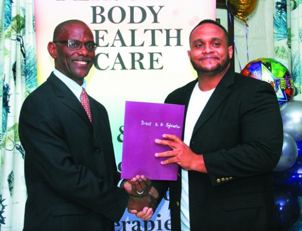 Executive Director of the Barbados Coalition of Service Industries (BCSI), Graham Clarke (left), presenting Brent Sylvester with his Reflexology certificate.