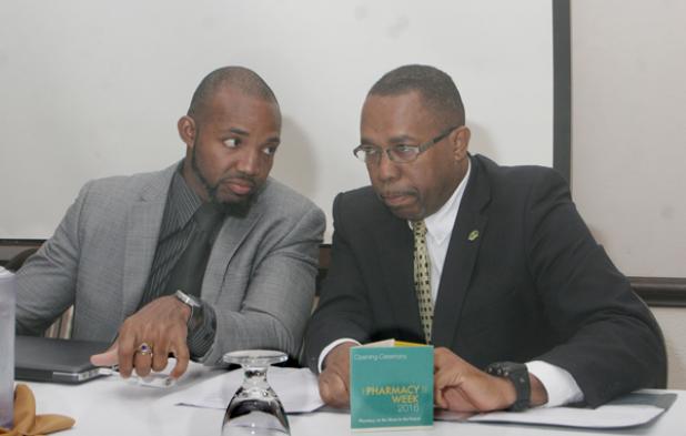 President of the Barbados Pharmaceutical Society, Paul Gibson (right) chatting with featured speaker Dr. Damian Cohall yesterday at Savannah Hotel during the opening ceremony of Pharmacy Week. 