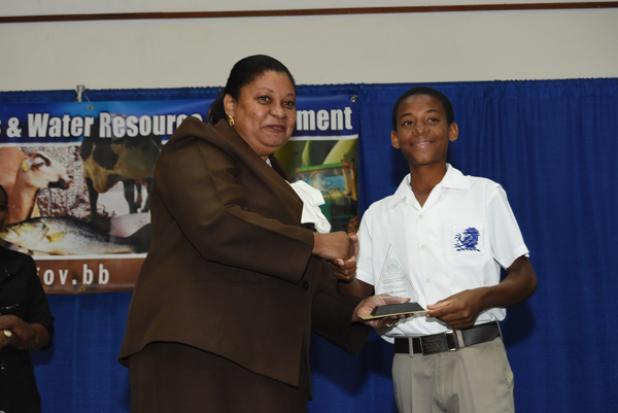 Jehru Latchman of St. George Secondary School received the award for his team, which captured first place in the Open-Field Gardening (Secondary) Category, in the Grow Well! School Gardening Competition, from Permanent Secretary in the Ministry Of Agriculture, Esworth Reid.
