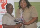 Recipient of the Julie Alleyne Common Entrance Award, Shermaria Brathwaite, receiving her prizes from Cyrilene Bryan, Secretary of the Board of Directors of the Light & Power Employees Co-operative Credit Union Ltd.