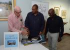 Author of the Barbados Heritage in Pictures book, Professor Emeritus Sir Henry Fraser (left), showing Minister of Tourism, Richard Sealy (centre), features of the book, as publisher Errol McCollin looks on, during Tuesday’s launch.